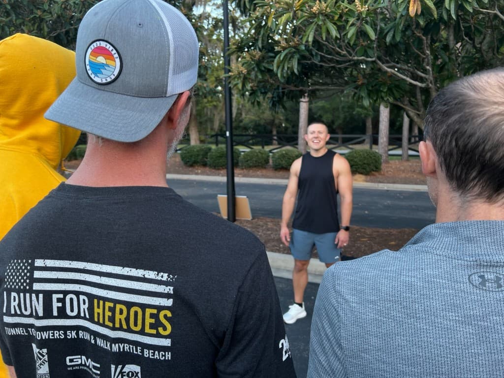 Men gathered in a circle listening before the workout begins